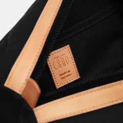 Inside of black toiletry bag with leather label stamped Crud Made in Sweden