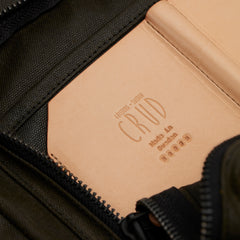 Heavy-duty leather and waxed canvas backpack with brass zippers