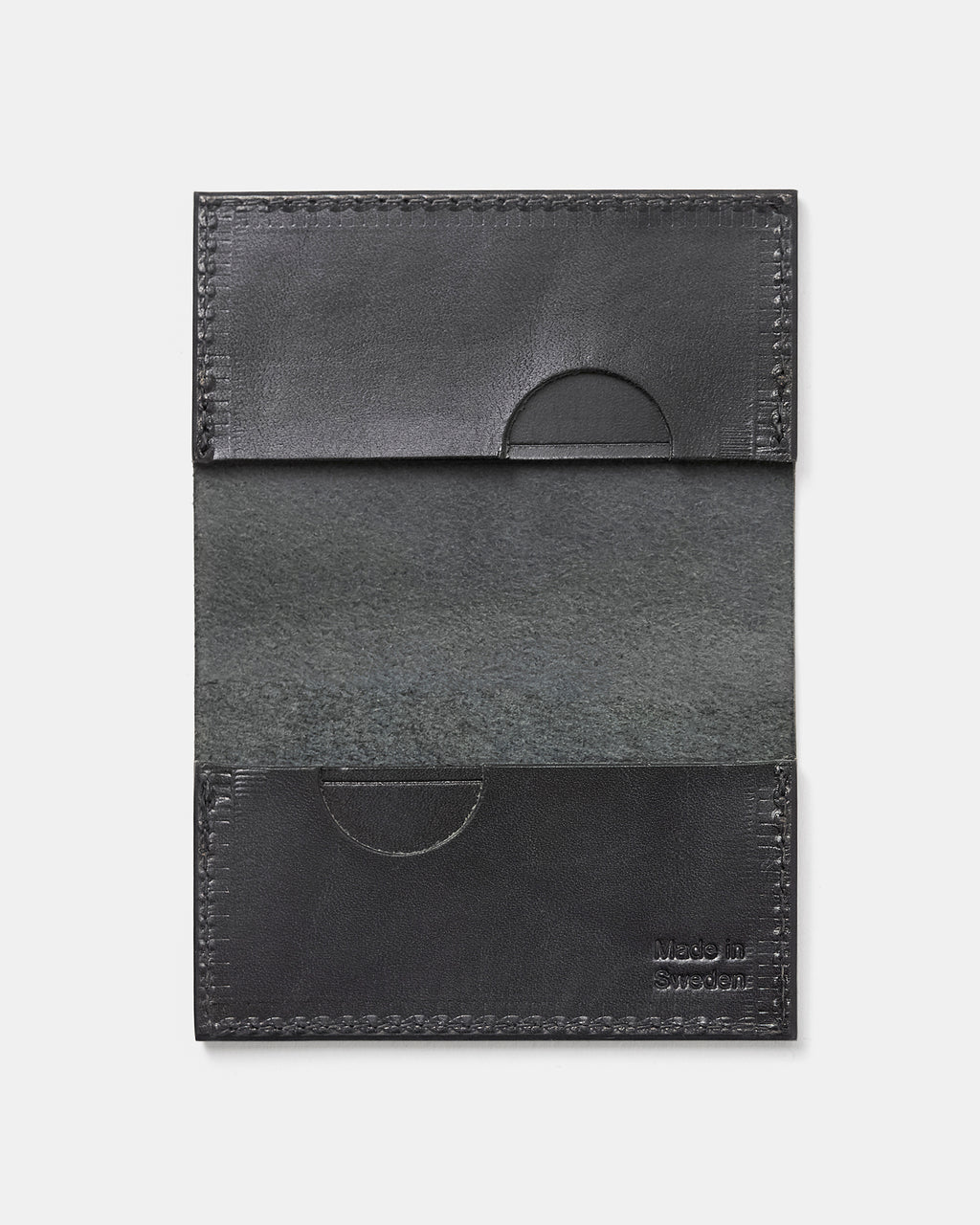 Black leather card case with recessed slots and polished edges